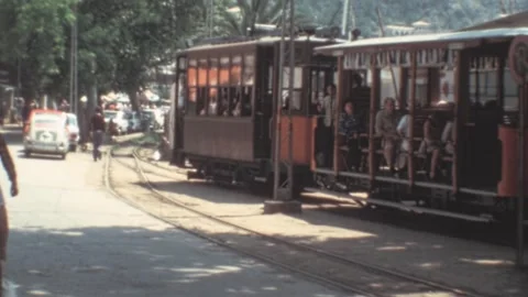 Port de Soller, Mallorca - 1977: Tourists enjoy a retro tram ride during summer Stock Footage 308714951