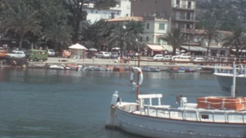 Port de Soller, Mallorca - 1977: Harbor with tourists walking and boats moored Stock Footage 308714956