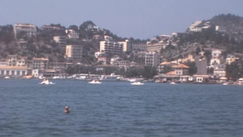 Port de Soller, Mallorca - 1977: Panorama revealing sunlit cityscape and harbor Stock Footage 308714987