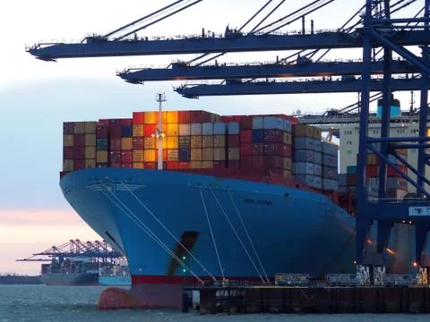 Port of Felixstowe, Suffolk, cranes loading containers onto Ebba Maersk at dusk Foto stock