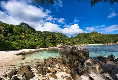 Port glaud beach, Beach, rock boulders and mountain, Mahe Seychelles Foto stock