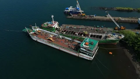 Port scene shows large ship anchored with green deck. Ideal for business concept Vídeos de archivo 335300341