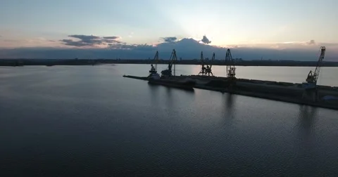 Port at sunset. The ship is ready to load. The camera is flying over the sea Stock Footage 65403669