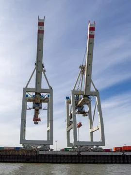 In port there are cranes for loading and unloading ships Stock Photos