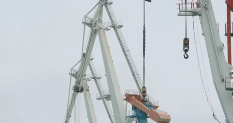 Port towering cranes stand aligned against cloudy sky Video stock 320435526