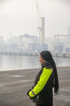 Port worker with cargo ship background Stock-Fotos
