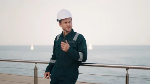 Port worker reporting about status of cargo by walkie talkie radio while working Stock Footage 165283545