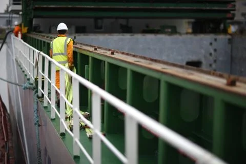 Port workers dragged slings for loading on board ship cargo ship Stock Photos