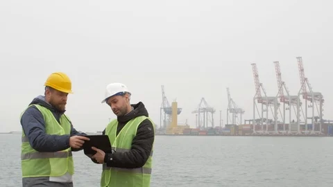 Port workers in helmets are looking at documents. sea port Stock Footage 99351646