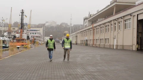 Port workers in helmets go to the port and talks go to port Stock Footage 99351794
