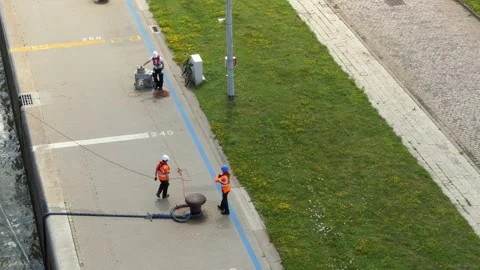Port workers put a mooring rope on the bollards. Stock Footage 131461788