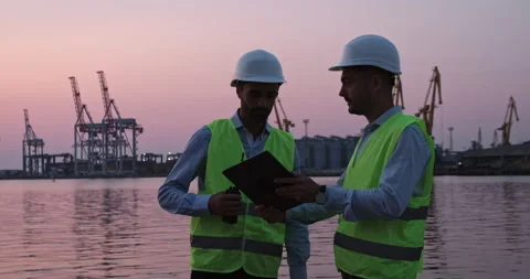 Port workers regulate cranes via tablet and walkie-talkie Stock Footage 166054209