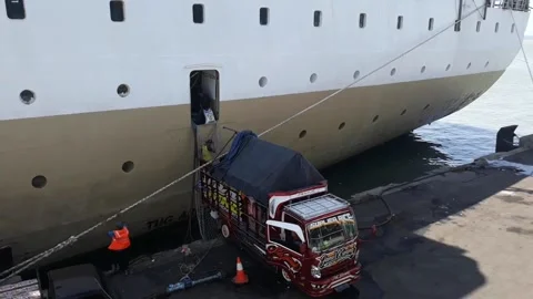 Port workers in trucks loading goods onto cargo ships 스톡 동영상 221892692