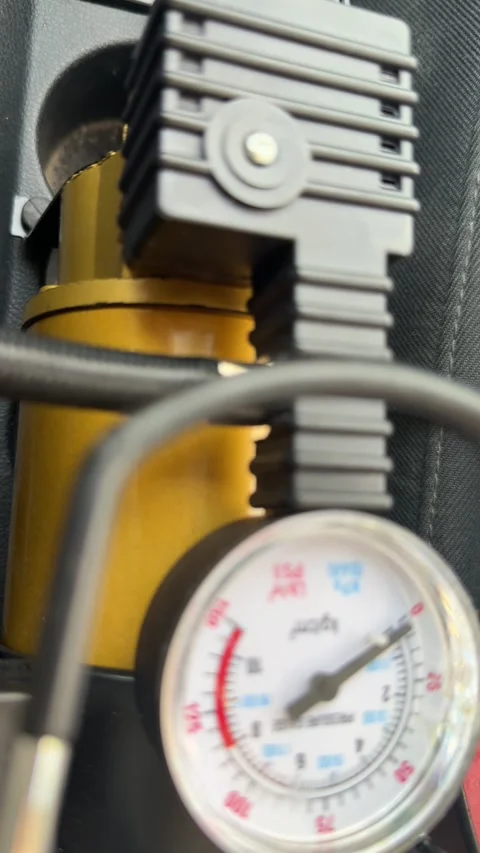 Portable air compressor and pressure gauge operate during car tire inflation, Vídeo Stock 337115154