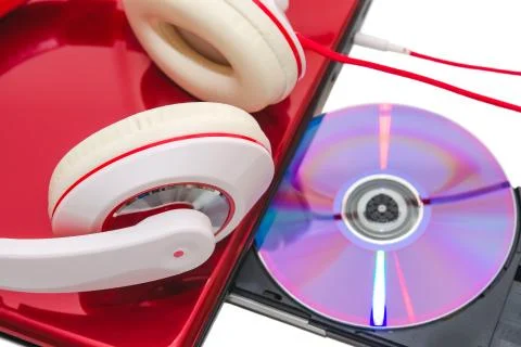 Portable computer with dvd disc and red white headphones Foto stock