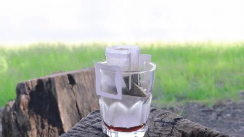 Portable Drip Coffee Being Poured Slowly with Hot Water at Lakeshore Campsite Stock Footage 338294592