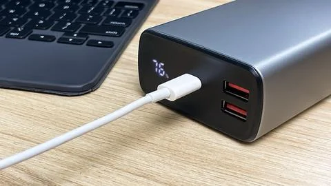 Portable external battery with digital display while charging the device Fotos de archivo