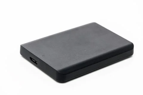 Portable external hard drive resting on a white surface, ideal for data sto.. Stockfoto's