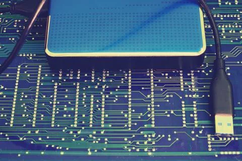 Portable hard disk on the background of the circuit board Stock Photos