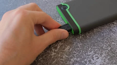 Portable hard drive connected to laptop to transfer data or documents, close-up Stock Footage 250227964