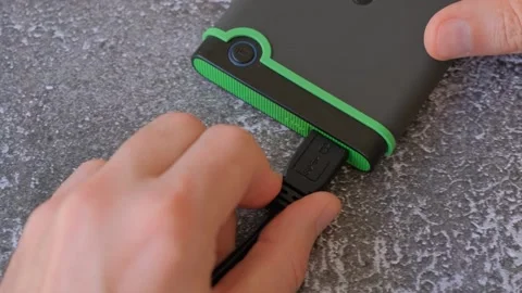 Portable hard drive connected to laptop to transfer data or documents, close-up Stock Footage 253768671