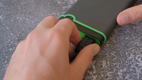Portable hard drive connected to laptop to transfer data or documents, close-up Stock Footage 256881216
