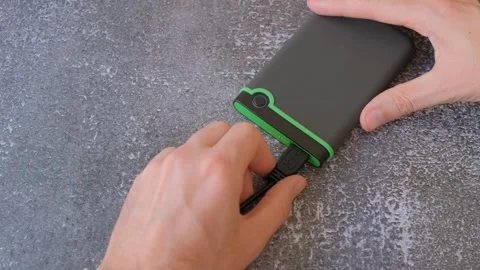 Portable hard drive connected to laptop to transfer data or documents, close-up Stock Footage 256881242