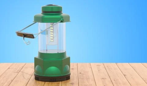 Portable LED Camping Lantern Flashlight on the wooden table, 3D rendering Illustrazione stock