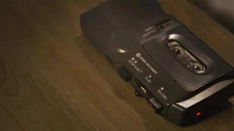 Portable mini cassette recorder capturing voice on wooden surface Stock Footage 334885799