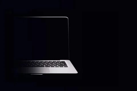 Portable modern silver computer on a black background. Stock Photos