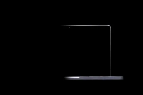 Portable modern silver computer on a black background. Stock Photos