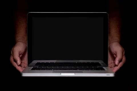 Portable modern silver computer on a black background. Stock Photos