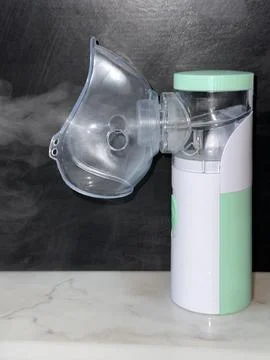 Portable Nebulizer with Steam Mist on Dark Background 写真素材