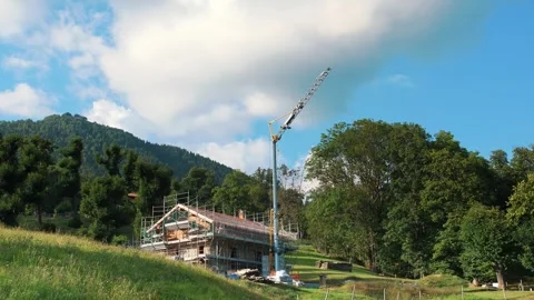A portable, quickly-assembled construction crane in the Alps. A small crane for Vídeos de archivo 258054121