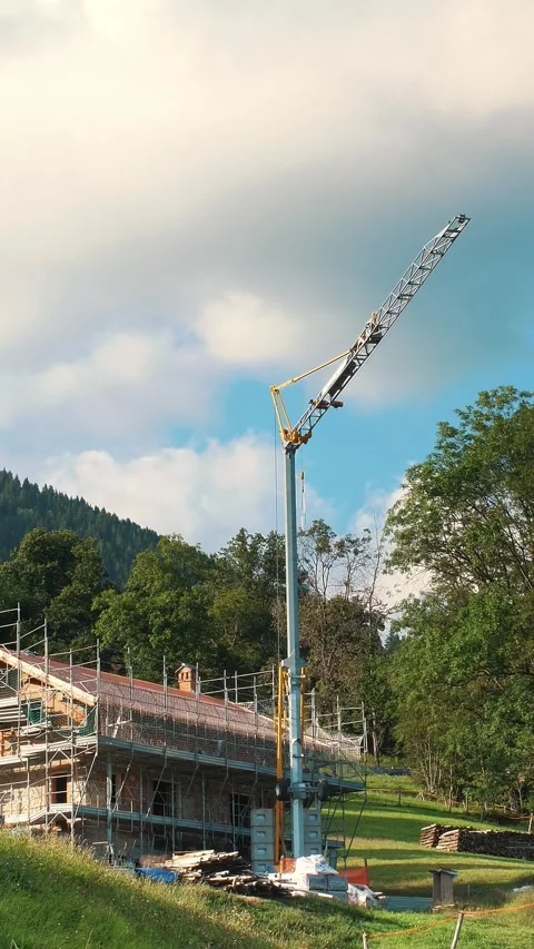 A portable, quickly-assembled construction crane in the Alps. A small crane for Video stock 316464147