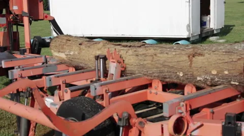 Portable sawmill positions log with claws Stock Footage 40472348