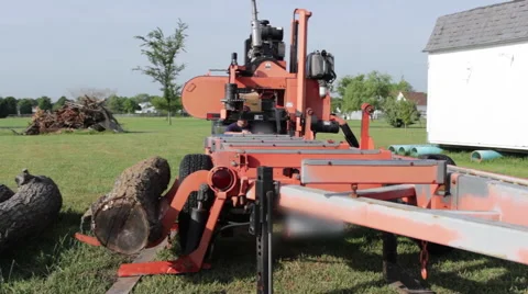 Portable sawmill rolls log onto rails Stock Footage 40472368