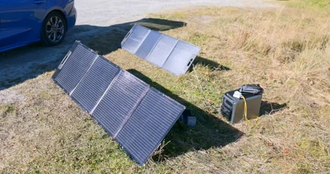 Portable solar panel charging outdoor power station in nature Stock Footage 323157767