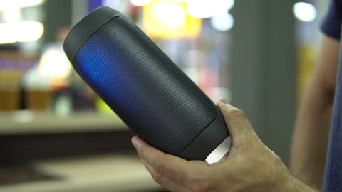 Portable speaker glows in hand. Stock Footage 91323858