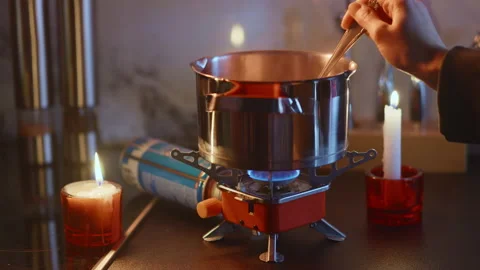 Portable stove usage at home during blackout, tourist gas burner, stiring dish Stock Footage 231464510