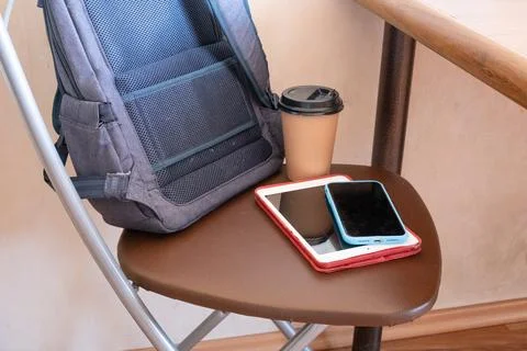 Portable workspace setup with backpack, tablet, smartphone, and takeaway coff Stock Photos