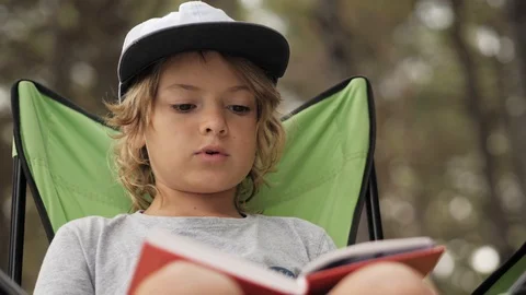 Portarit of child reading a book on pine wood background. Stock Footage 112011968