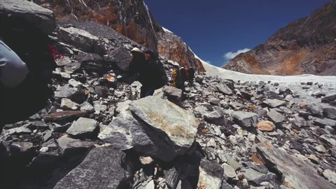 Porters walk along difficult path at Cho La pass in the Nepal Himalaya. Stock Footage 72906610