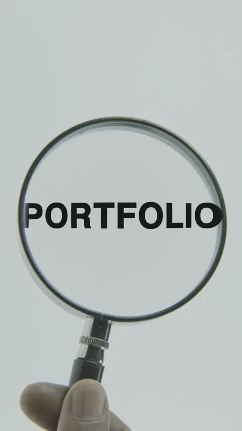 Portfolio text or word highlighted by a magnifying glass in a hand Stock Footage 303500148
