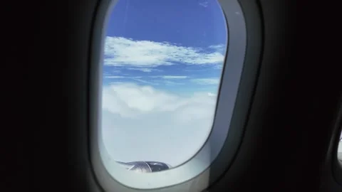 Porthole window, view of clouds from airplane passenger seat Stock Footage 313891282