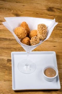 Portion of assorted croquettes served with dark mustard. On wooden table Stock Photos