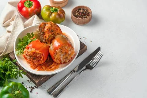 A portion of bell pepper stuffed with meat and rice with fresh herbs on a lig Stock Photos