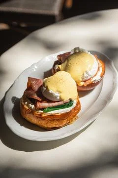Portion of benedict eggs with sauce and brioche Stock Photos
