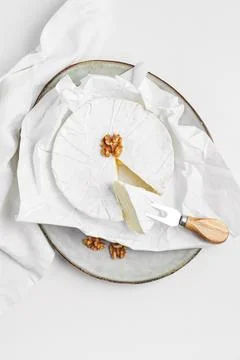 Portion of brie cheese with walnuts on ceramic plate Stock Photos