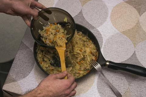 A portion of cooked stewed cabbage with pork is placed on a plate with a wood Stock Photos